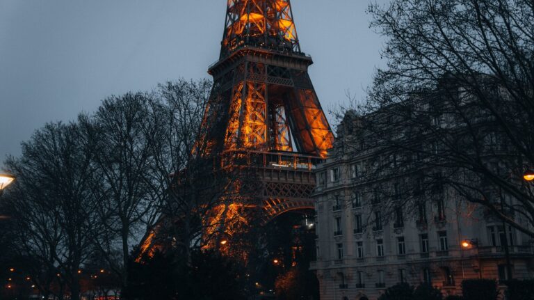 the eiffel tower is lit up at night